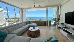 a living room with a couch and a large window at Dee's Retreat Rainbow Beach in Rainbow Beach