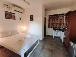 a room with a white bed with two towels on it at Sarovar Ashwem in Mandrem