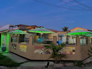 a building with green umbrellas on the side of it at Pousada & Espaço Orlla 39 in Maricá