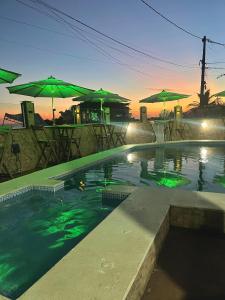 a swimming pool with umbrellas and a swimming poolvisorangering at Pousada & Espaço Orlla 39 in Maricá