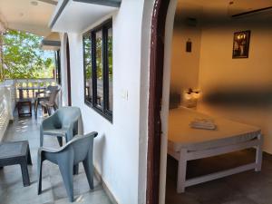 a room with a table and chairs on a balcony at Sarovar Ashwem in Mandrem
