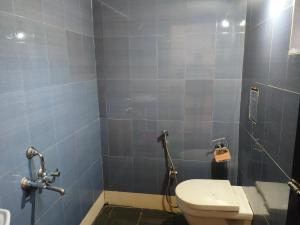 a bathroom with a toilet and a blue tiled wall at Sarovar Ashwem in Mandrem +43 photos