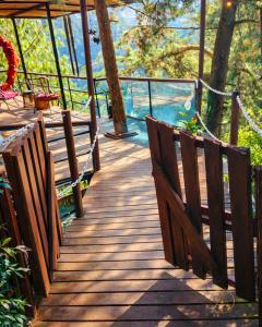 a wooden walkway with benches and a view of the water at Omghat Glamping - Domo Ganesha in El Peñol