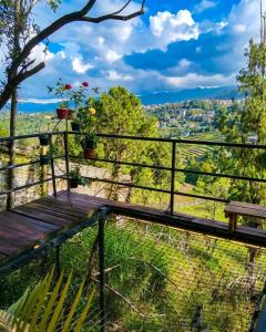 a balcony with a wooden bench and a view at Omghat Glamping - Domo Ganesha in El Peñol