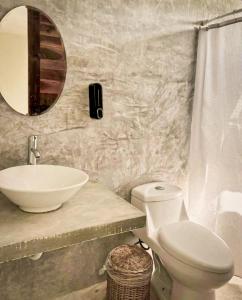 a bathroom with a sink and a toilet and a mirror at Apartamento Casa 24 in Bacalar +11 photos