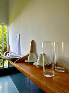 a wooden counter with vases and glasses on it at surf dom hotel & restaurants in Ahangama