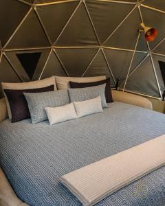 a large bed with pillows in a room at Omghat Glamping - Domo Sarasvasti in El Peñol