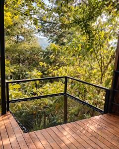 a balcony with a black railing on a wooden deck at Omghat Glamping - Domo Sarasvasti in El Peñol