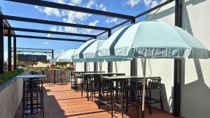 eine Terrasse mit Tischen, Stühlen und einem Sonnenschirm in der Unterkunft Fed Hotel in Semaphore