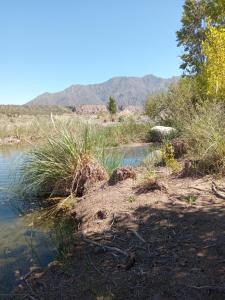 a body of water with mountains in the background at Posada del Río 2 in Ciudad Lujan de Cuyo