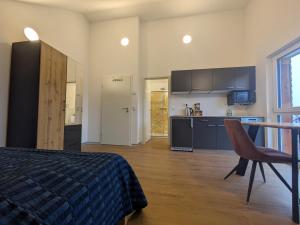 a bedroom with a bed and a table and a kitchen at LechApartments in Kaufering