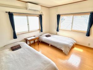 two beds in a room with two windows at SUBAKO - Vacation STAY 90330v in Yurihonjo