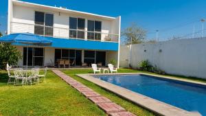a house with a swimming pool in the yard at Home in Tequesquitengo in Tequesquitengo
