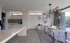 a dining room and kitchen with a table and chairs at Maerim Luxury 3BR Pool Villa with Mountain View in Ban Tai