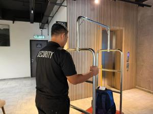 a man standing in front of a door with a suitcase at ALL IN HOTEL in Kangar