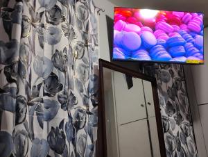 a flat screen tv on a wall next to a mirror at Grove#10 in Irvington