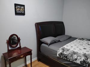 a bedroom with a bed and a table and a mirror at Grove#10 in Irvington