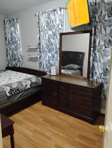 a bedroom with a bed and a dresser with a mirror at Grove#10 in Irvington