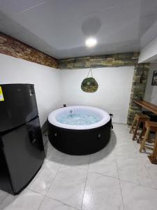 a large bath tub in a room with a refrigerator at Apartamento de lujo con jacuzzi en Jericó in Jericó