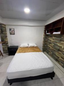 a bed in a room with a brick wall at Apartamento de lujo con jacuzzi en Jericó in Jericó
