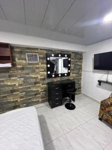 a bedroom with a wall with a tv and a desk at Apartamento de lujo con jacuzzi en Jericó in Jericó