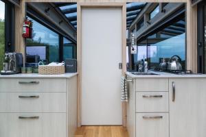 an open door to a kitchen in a house at Rewarewa PurePod in Helensville