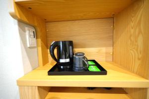 a black coffee maker sitting on a tray in a cabinet at Rita Hotel Namba in Osaka