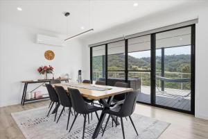 a dining room with a table and chairs with a view at Eildon Valley Views in Eildon +17 photos