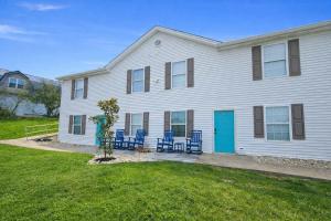 a white house with blue chairs in the yard at Arkstone Retreat 2 - Chic 2 Bedroom in Williamstown