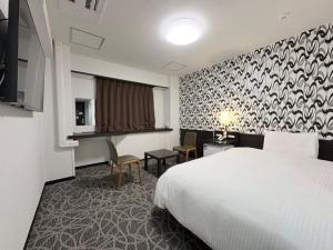 a hotel room with a bed and a desk at APA Hotel Okhotsk Kitami in Kitami