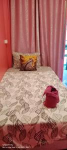 a bed with a red bag on top of it at 3 Star and the Sun in Ban Nua