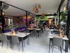 a restaurant with tables and chairs in a room at Khao Sok Las Orquideas Resort in Khao Sok National Park
