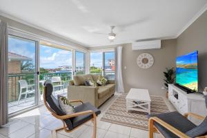 a living room with a couch and a tv at Seychelle unit 5 Kings Beach in Caloundra