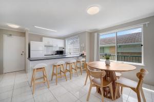 a kitchen and dining room with a table and chairs at Seychelle unit 5 Kings Beach in Caloundra +7 photos
