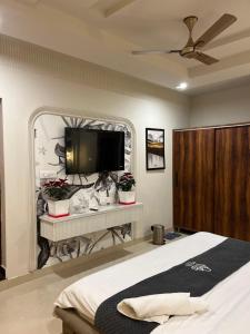 ein Schlafzimmer mit Bett und Flachbildfernseher in der Unterkunft Hotel H Plus in Kurukshetra