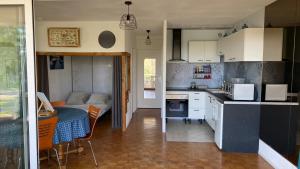 a small kitchen with a table and a dining room at L'Hermione in Dienville