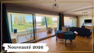 a living room with a table and a living room with a view at L'Hermione in Dienville