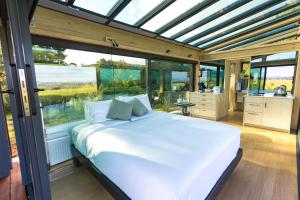 a bed in a room with a large window at Matū PurePod - Waitomo in Otorohanga