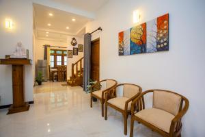 a living room with chairs and a painting on the wall at Palms shede Villa in Habaraduwa Central