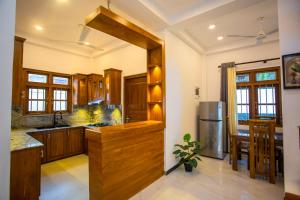 a kitchen with wooden cabinets and a stainless steel refrigerator at Palms shede Villa in Habaraduwa Central