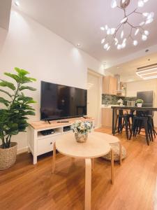 a living room with a table and a large television at Relaxing Mountain View 2BR Fast WiFi and PS5 in Manila