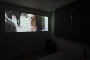 a tv screen in a dark room with a woman on it at Sunset Stay Osong in Ch'ŏngnyong