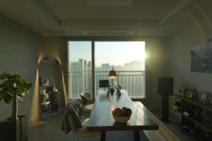 a living room with a table and a large window at Sunset Stay Osong in Ch'ŏngnyong