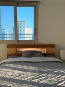 a bedroom with a bed and a large window at Sunset Stay Osong in Ch'ŏngnyong