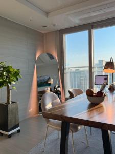 a dining room with a table and chairs and a large window at Sunset Stay Osong in Ch'ŏngnyong