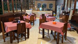 a restaurant with tables and chairs in a restaurant at Baron Ndut's Cottage in Mantaak