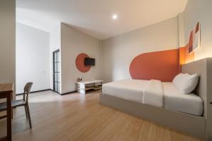 a bedroom with a bed and a table and a desk at Cove Haven in Surabaya