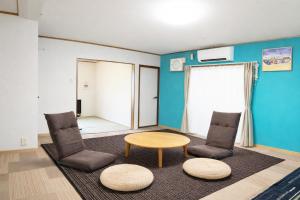 a living room with two chairs and a table at Seaside Pension Petit Shirahama in Shirahama