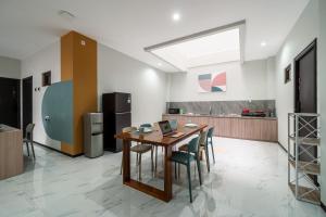 a kitchen with a wooden table and chairs at Cove Haven in Surabaya
