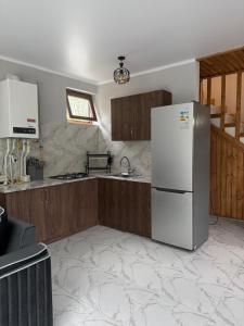 a kitchen with a refrigerator and wooden cabinets at Eva Grand House Dilijan in Dilijan